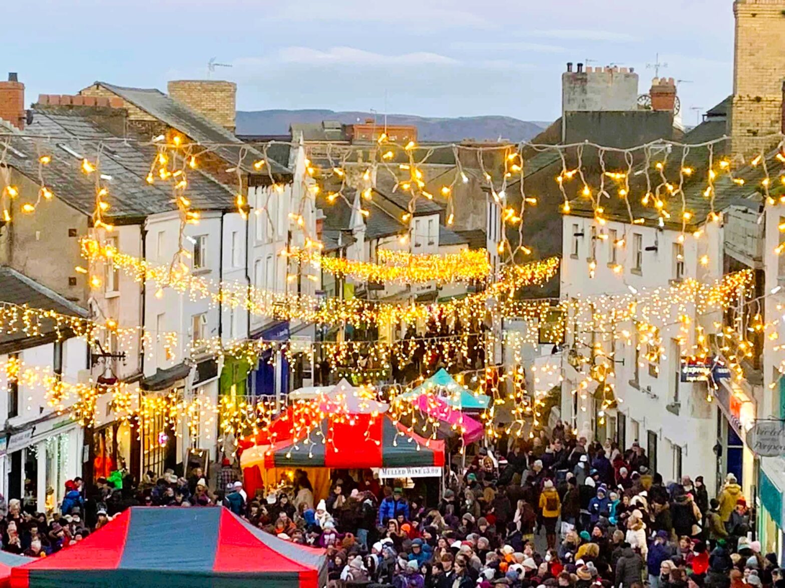 Ulverston Dickensian Christmas Festival street scene with visitors in Victorian costumes.