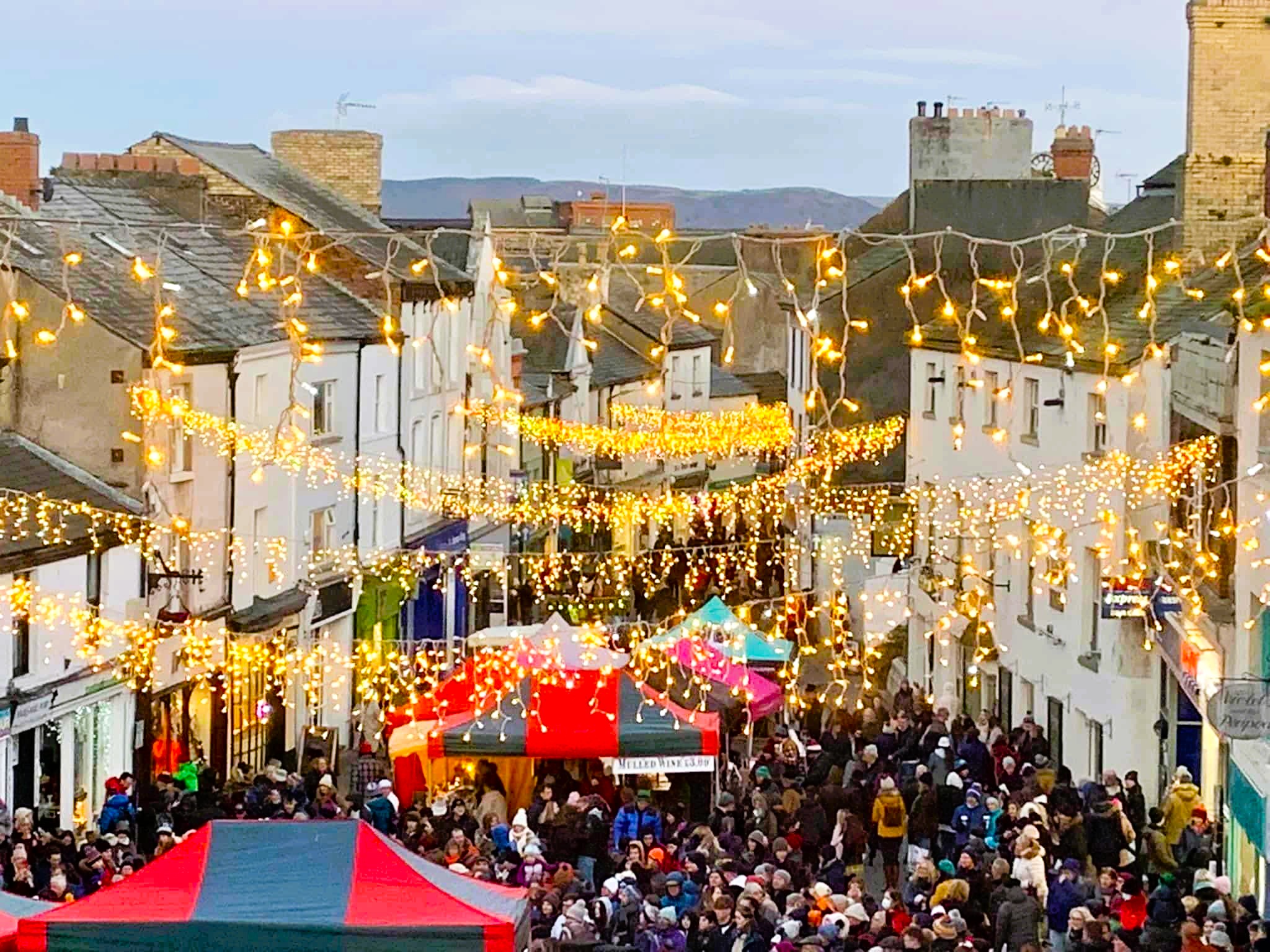Ulverston Dickensian Christmas Festival street scene with visitors in Victorian costumes.