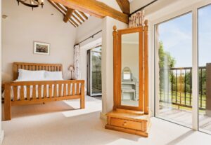 Large bedroom at Cartmel Hill holiday cottage with slide and fold doors opening onto the veranda
